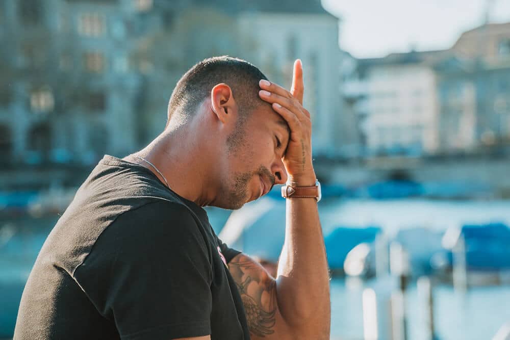 Man holding head in left hand