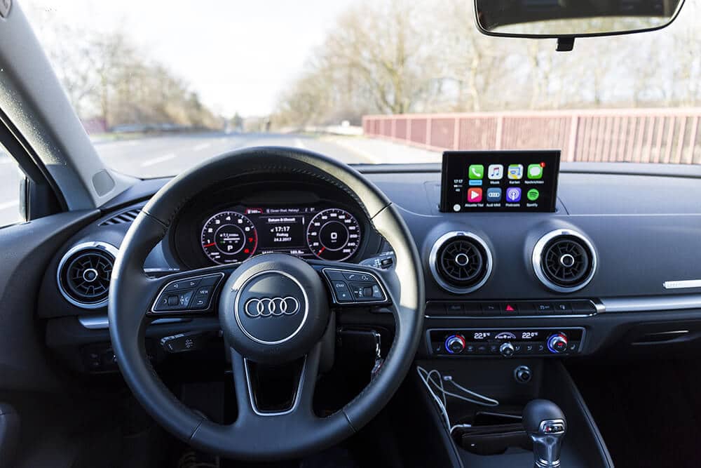 Inside of car, showing steering wheel and touch screen dash board