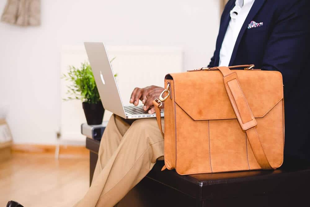 Person on laptop with messenger back next to them