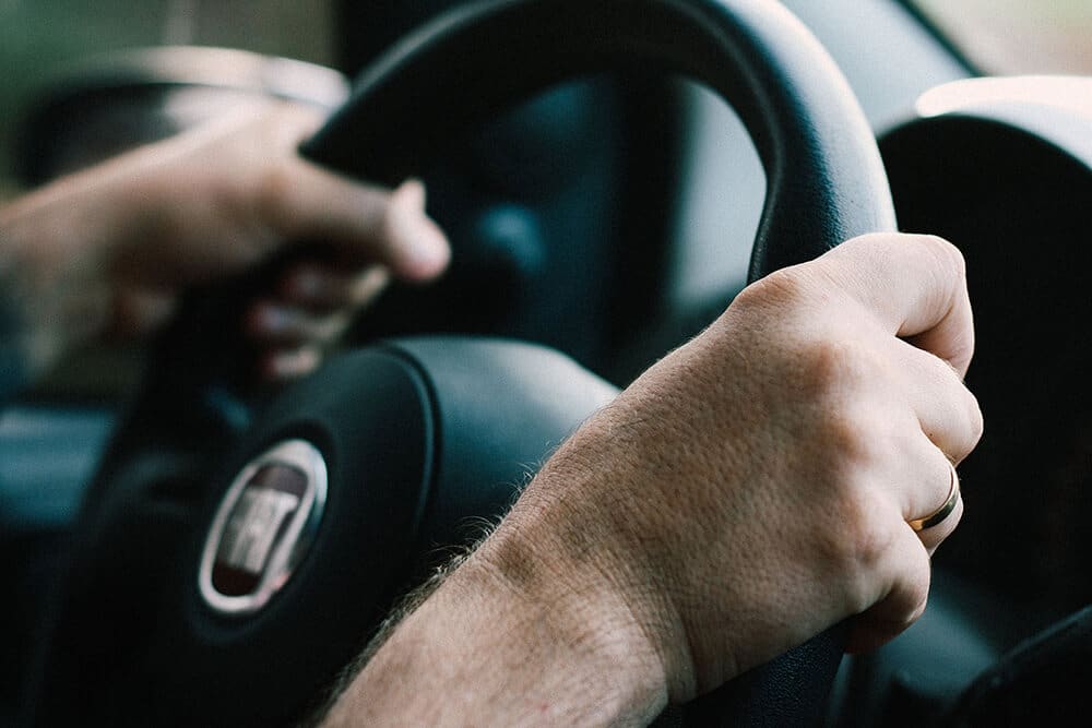 driver's hands on steering wheel