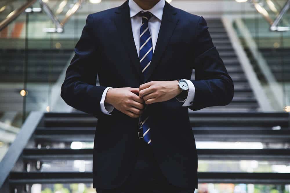 Person buttoning suit